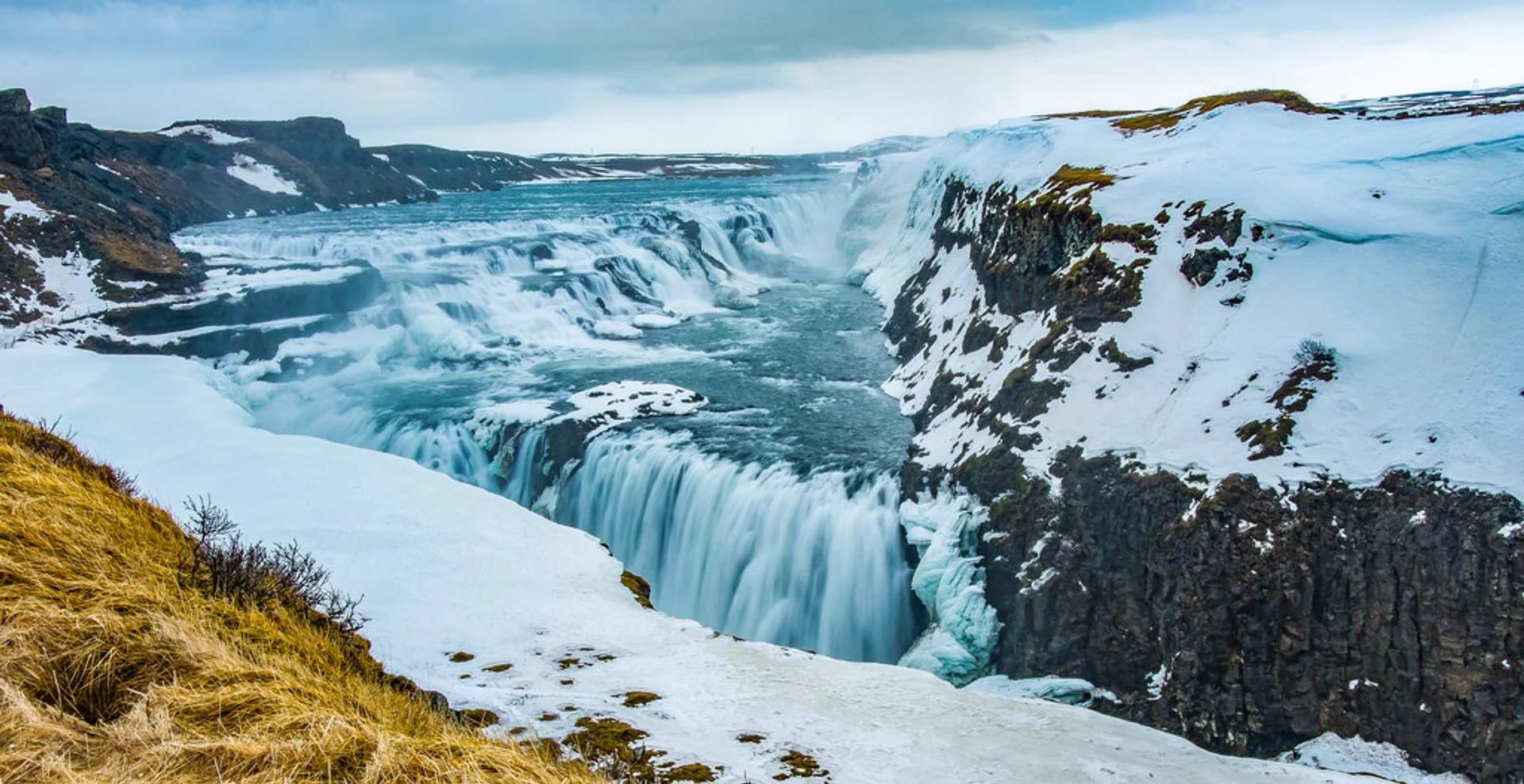 Iceland Golden Circle waterfalls cascading over rocky cliffs surrounded by lush greenery